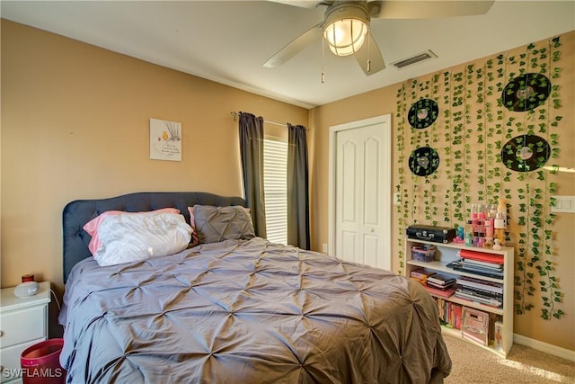 carpeted bedroom with visible vents, baseboards, a closet, and a ceiling fan