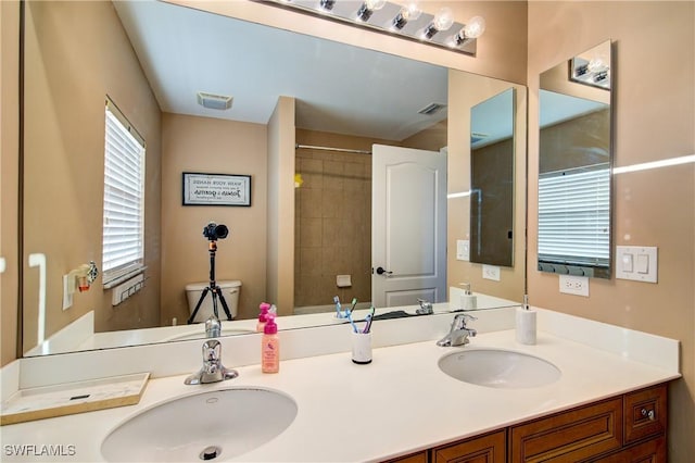 full bathroom featuring double vanity, visible vents, and a sink