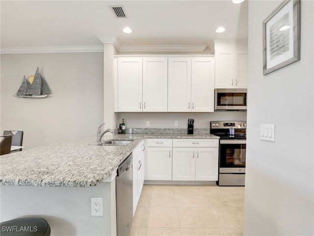 kitchen featuring light tile patterned flooring, stainless steel appliances, a sink, white cabinetry, and light stone countertops