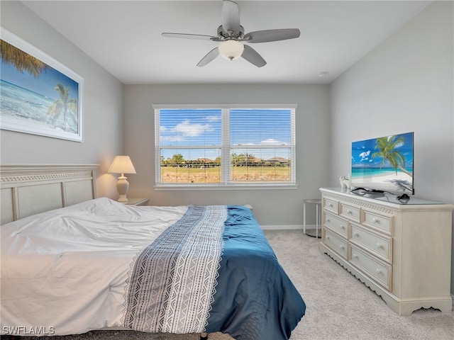 bedroom featuring light carpet, ceiling fan, and baseboards