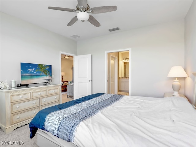 bedroom with ensuite bathroom, ceiling fan, visible vents, and light colored carpet