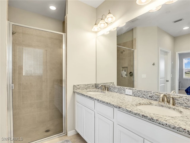 full bathroom with visible vents, a sink, a shower stall, and double vanity