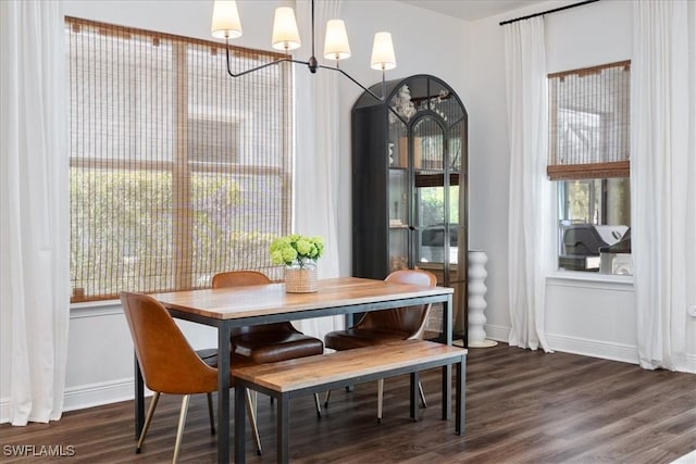 dining room with dark wood-style floors, a chandelier, and baseboards