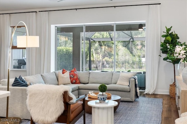 living room with a sunroom, a healthy amount of sunlight, and dark wood finished floors