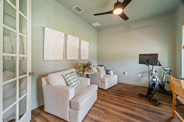 living area with baseboards, visible vents, ceiling fan, and wood finished floors