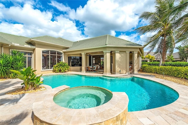 view of swimming pool with a patio area, a pool with connected hot tub, and ceiling fan