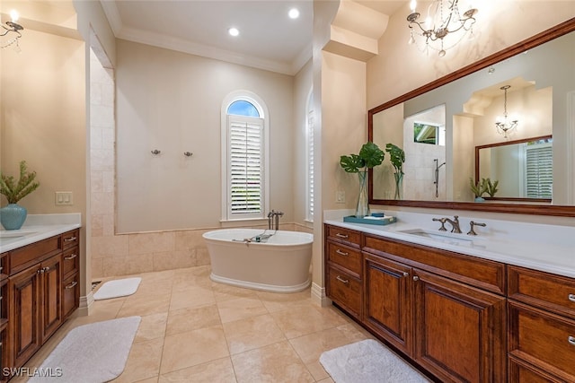 full bathroom featuring two vanities, crown molding, an inviting chandelier, and a sink