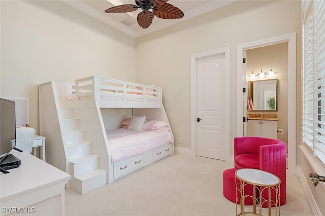 carpeted bedroom featuring ensuite bath, crown molding, and baseboards