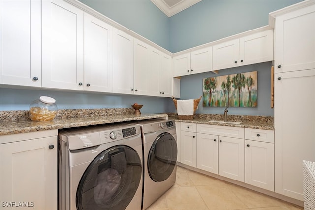 laundry room featuring a sink, washer and dryer, cabinet space, crown molding, and light tile patterned floors