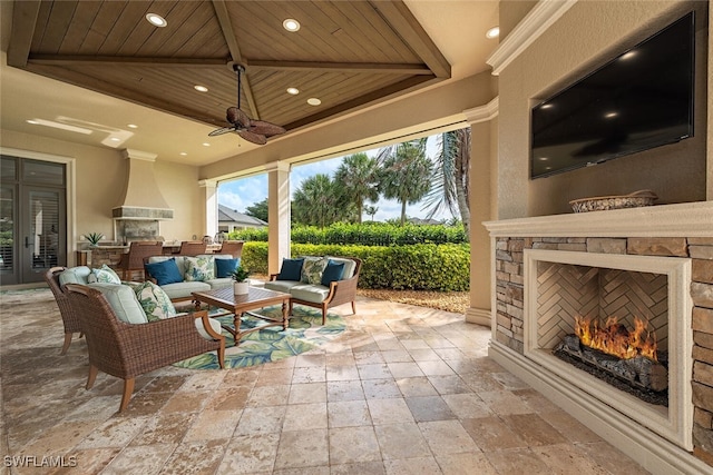 view of patio / terrace featuring an outdoor living space with a fireplace and a ceiling fan