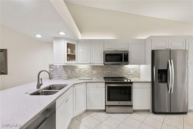 kitchen with appliances with stainless steel finishes, white cabinets, a sink, and glass insert cabinets