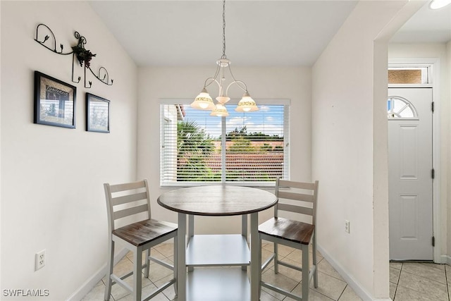 dining space with a notable chandelier, baseboards, and light tile patterned floors