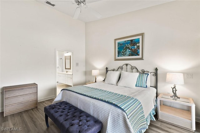 bedroom featuring ensuite bath, wood finished floors, visible vents, and baseboards