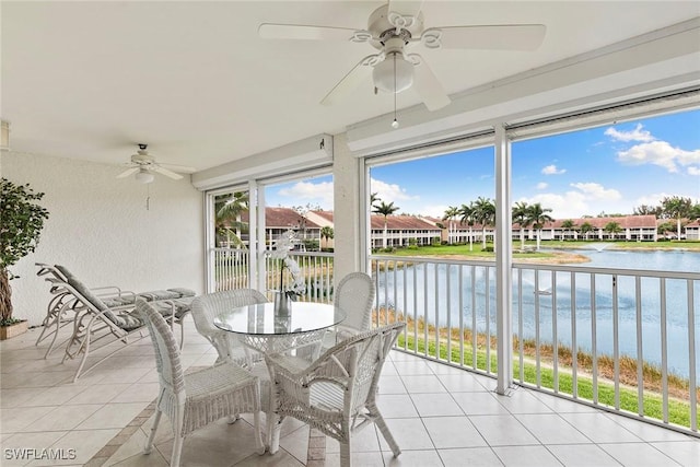 sunroom / solarium with a water view, ceiling fan, and a residential view