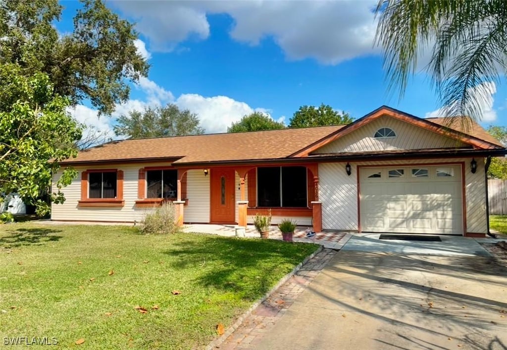 ranch-style house with driveway, a garage, and a front yard