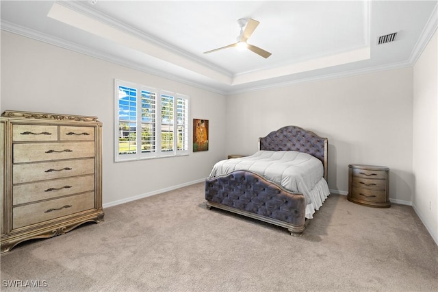 bedroom featuring a raised ceiling, light carpet, and visible vents