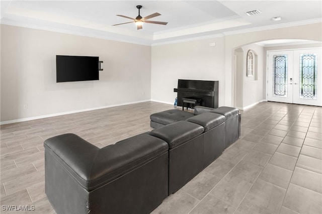 living room with arched walkways, french doors, visible vents, ornamental molding, and baseboards