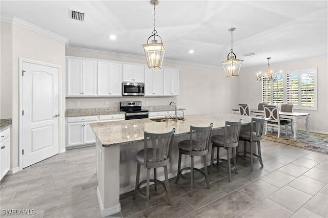 kitchen featuring a breakfast bar, a sink, visible vents, appliances with stainless steel finishes, and crown molding