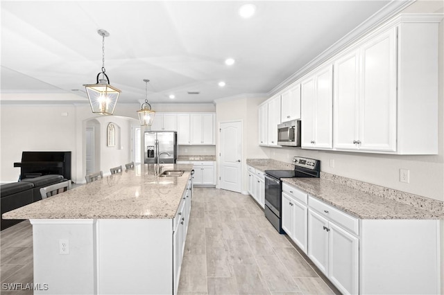 kitchen with arched walkways, stainless steel appliances, recessed lighting, white cabinets, and a sink