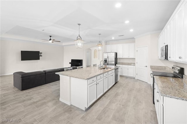 kitchen with arched walkways, white cabinets, light wood-style flooring, appliances with stainless steel finishes, and open floor plan