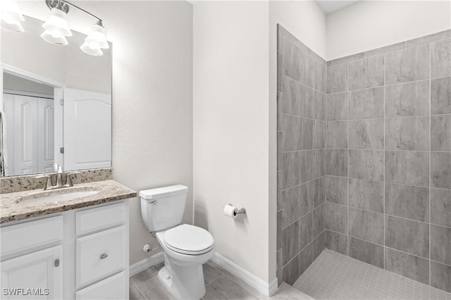 full bathroom with tiled shower, toilet, an inviting chandelier, tile patterned flooring, and vanity