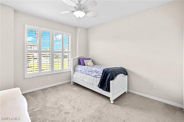 carpeted bedroom featuring ceiling fan and baseboards