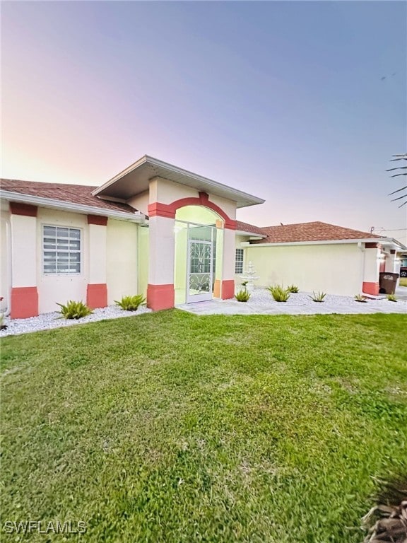 view of front of house featuring a front yard and stucco siding