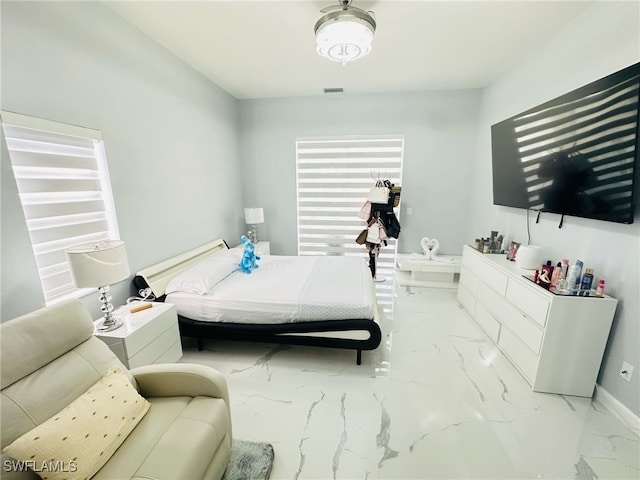 bedroom with marble finish floor, visible vents, and baseboards