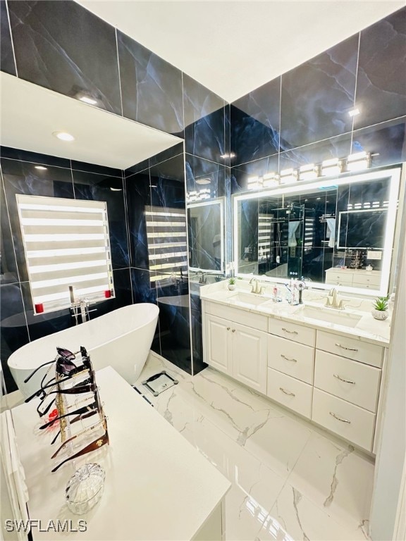 full bath featuring marble finish floor, double vanity, a freestanding bath, a tile shower, and a sink