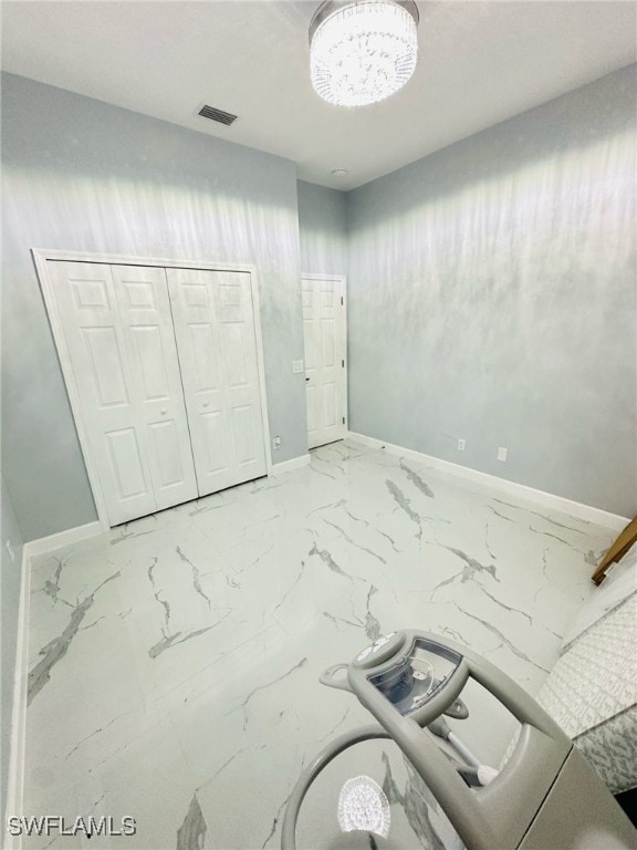 unfurnished bedroom with marble finish floor, a closet, visible vents, and baseboards