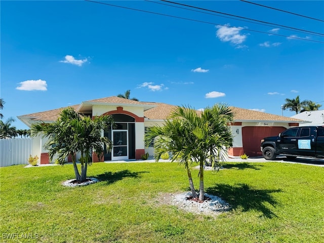 view of front facade with an attached garage, fence, a front lawn, and stucco siding