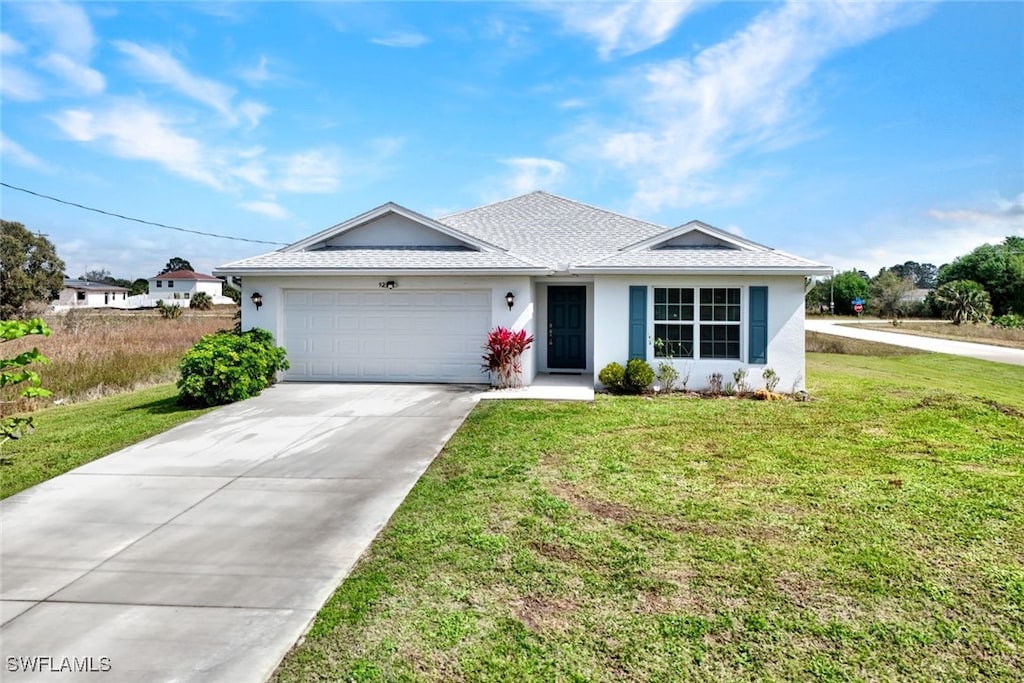 ranch-style house featuring driveway, a front lawn, an attached garage, and stucco siding