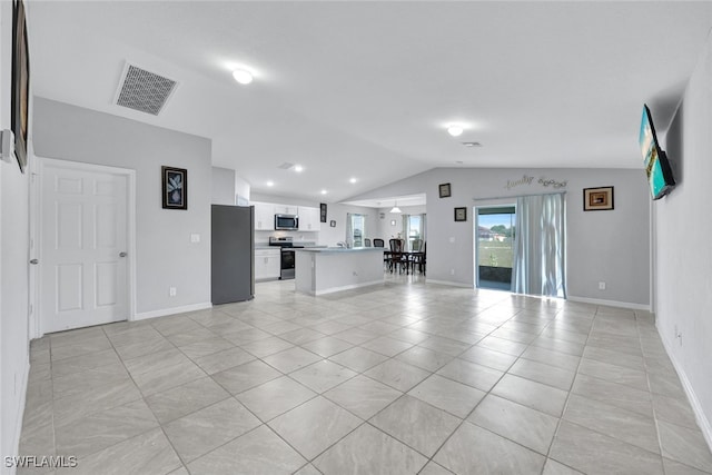 unfurnished living room featuring light tile patterned floors, baseboards, visible vents, and vaulted ceiling