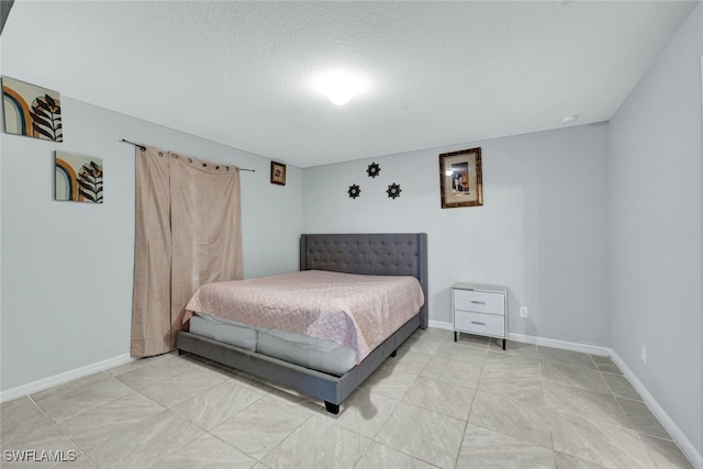 bedroom featuring a textured ceiling and baseboards