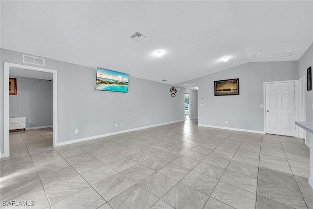 interior space with visible vents, vaulted ceiling, baseboards, and light tile patterned flooring