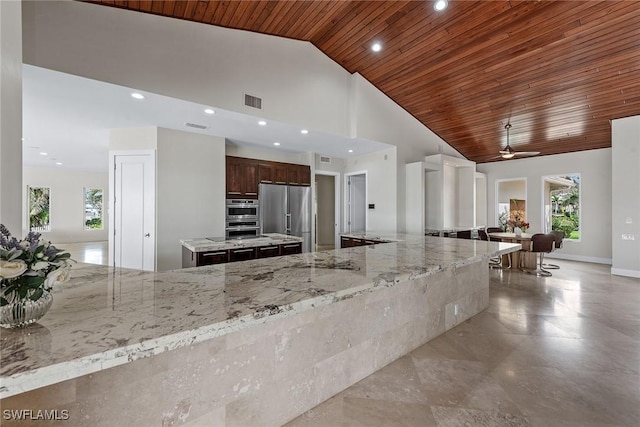 kitchen with high vaulted ceiling, recessed lighting, high end refrigerator, wood ceiling, and a large island