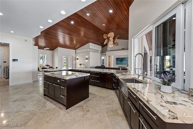 kitchen with lofted ceiling, wooden ceiling, black electric stovetop, and a sink