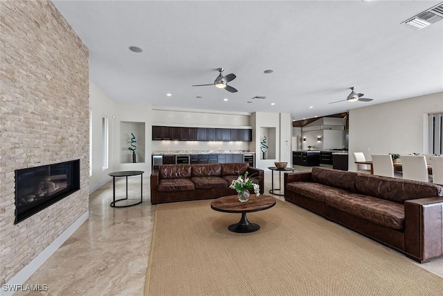 living area with a ceiling fan, visible vents, and a fireplace