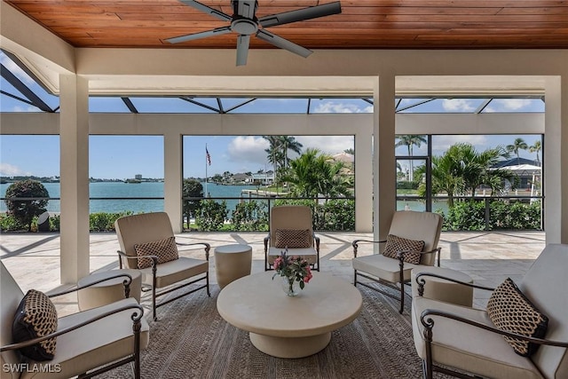 sunroom featuring a water view, wood ceiling, and a ceiling fan