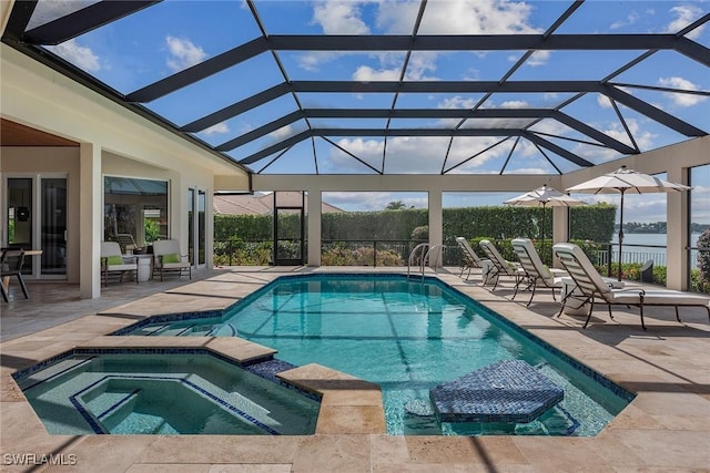 view of swimming pool featuring glass enclosure, a pool with connected hot tub, and a patio