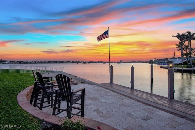 view of dock with a patio and a water view