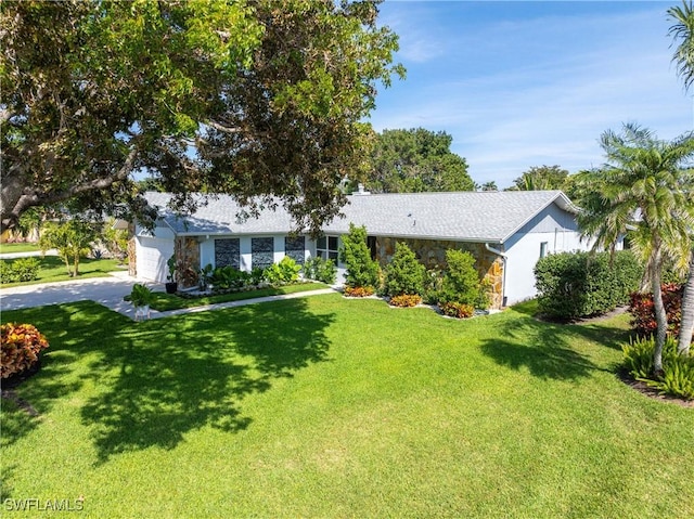 ranch-style house featuring driveway, a front lawn, and an attached garage