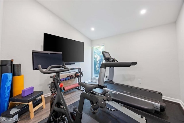 exercise area featuring recessed lighting, vaulted ceiling, baseboards, and wood finished floors