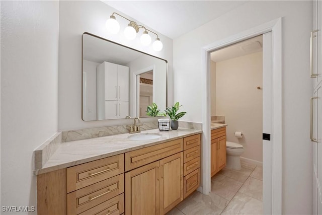 bathroom featuring toilet, marble finish floor, and vanity