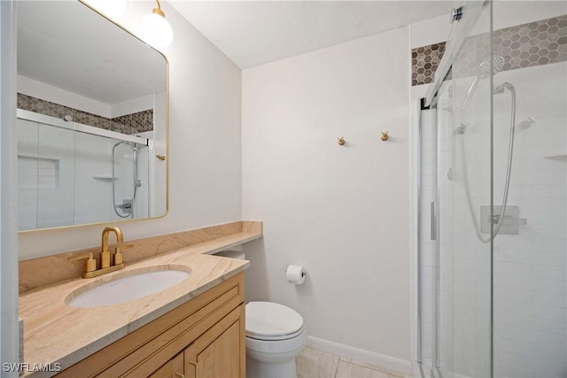 bathroom featuring a stall shower, baseboards, vanity, and toilet