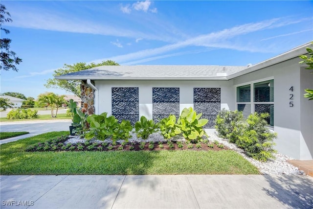 view of side of property featuring a yard and stucco siding