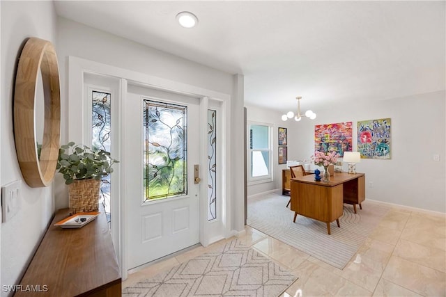 foyer entrance with baseboards and a chandelier