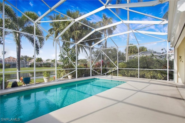 outdoor pool featuring a patio and glass enclosure