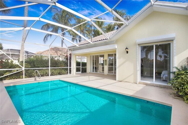 pool featuring glass enclosure and a patio