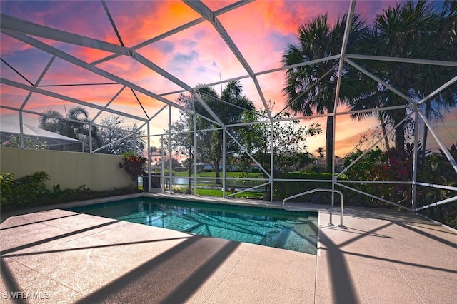 view of swimming pool featuring a patio, glass enclosure, and a fenced in pool